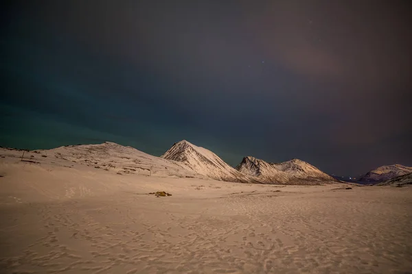 Noche dramática con muchas nubes y estrellas en el cielo sobre las montañas en el norte de Europa - Tromso, Noruega.larga velocidad de obturación . — Foto de Stock