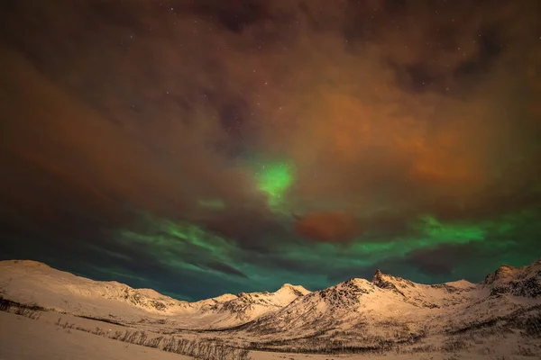 Drámai sarki fények, Aurora borealis sok felhők és csillagok az égen a hegyek felett Észak-Európában - Tromso, Norvégia.hosszú záridő. — Stock Fotó