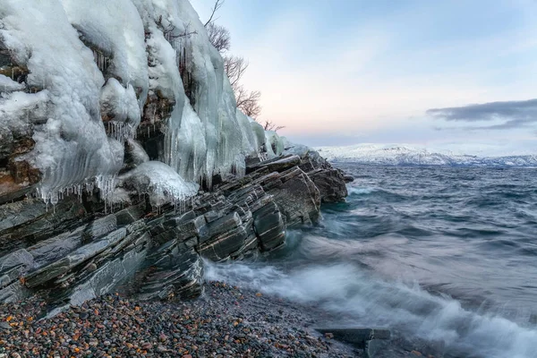 Icicli appesi alle rocce sulla riva Tornetrask, Svezia. Notte polare. lunga velocità dell'otturatore — Foto Stock