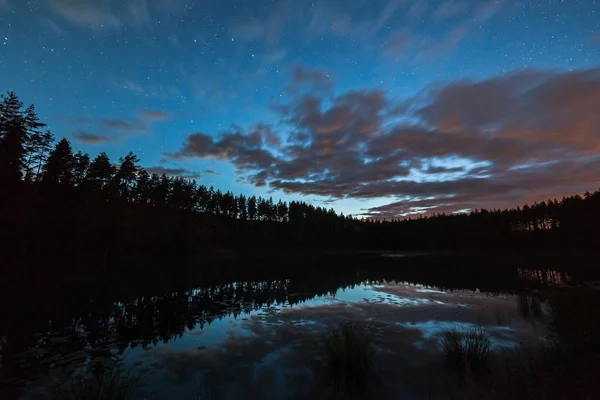 Un millón de estrellas en el cielo nublado sobre el lago en la noche. larga exposición. Vía Láctea — Foto de Stock