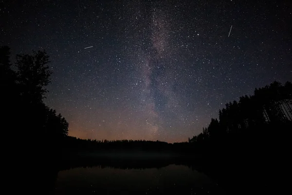 Milion gwiazd nad jeziorem w nocy. Długa ekspozycja. Ślad z latającego satelity. Droga mleczna — Zdjęcie stockowe