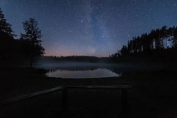 Milion gwiazd nad jeziorem w nocy. Długa ekspozycja. Ślad z latającego satelity. Droga mleczna — Zdjęcie stockowe