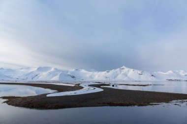 Kuzey Avrupa 'da kar çölü kış manzarası. İzlanda. Arkaplanda karlı dağlar.
