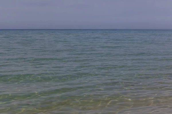 Vista de las olas azules en la playa de arena. Línea Horizon. Mar Caspio, costa de arenisca. ustyurt. Enfoque selectivo, velocidad de obturación larga —  Fotos de Stock