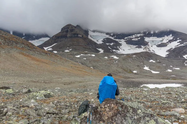 Caminante sentado en la piedra en las montañas y admirar el paisaje — Foto de Stock