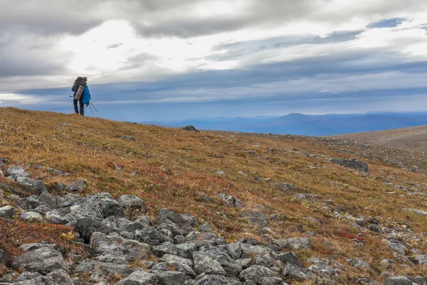 Hombre mochila excursionista en el sendero Kungsleden admirar la naturaleza de Sarek en Suecia Laponia con montañas, ríos y lagos, bosques de abedules y abetos. Principios de otoño colores en clima tormentoso — Foto de Stock
