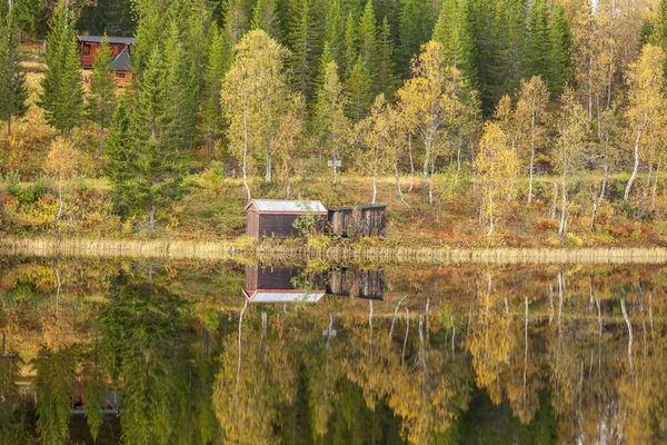 Mały drewniany dom znajduje odzwierciedlenie w wodzie w Lofoten, Norwegia. — Zdjęcie stockowe