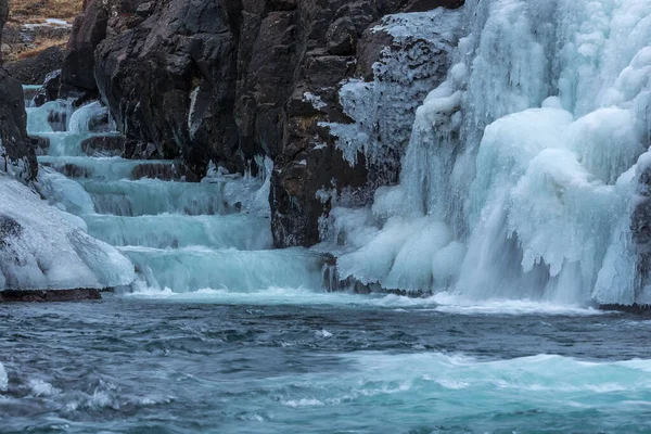 Uma cachoeira congelada com gelo em uma cor azul e branca no inverno. Islândia — Fotografia de Stock