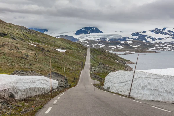 The road leading a mysterious gorge surrounded by clouds of the Norwegian mountains, selective focus — 스톡 사진