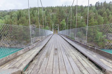 Norveç 'teki dağ nehri üzerindeki asma köprü. Peyzaj. Turkuaz nehir. Norveç 'te hızlı akan dağ nehri