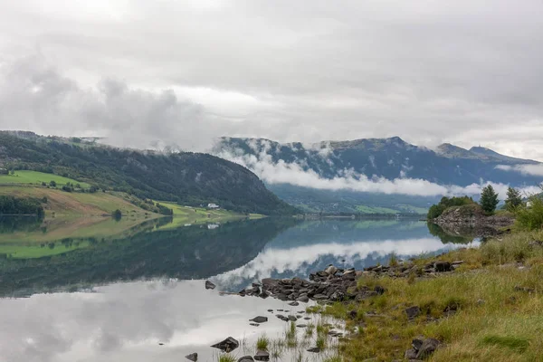 Egy misztikus fjord Norvégiában, hegyekkel és köddel a víz felett, gyönyörű monokróm kék színben. szelektív fókusz — Stock Fotó