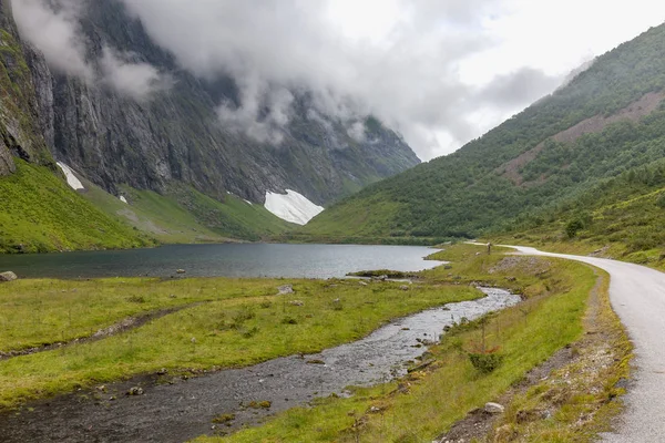 Cesta vedoucí tajemnou soutěskou obklopenou mraky norských hor, selektivní zaměření — Stock fotografie