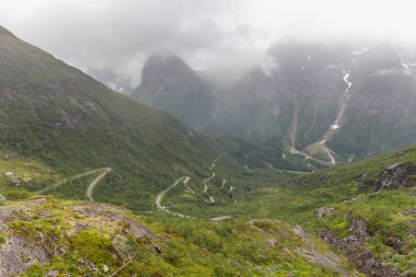Serpentine road in the mountains of Norway, troll staircase, gloomy gloomy weather, wet asphalt, selective focus