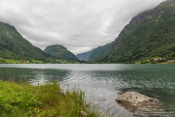 Fiorde norueguês e montanhas cercadas por nuvens, reflexão fiorde ideal em águas claras. foco seletivo . — Fotografia de Stock