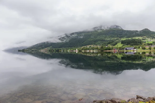 Fin del fiordo. Hermoso paisaje noruego. vista de los fiordos. Noruega reflejo ideal del fiordo en aguas claras En tiempo nublado. enfoque selectivo — Foto de Stock