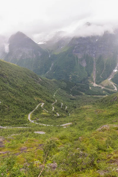 Estrada serpentina nas montanhas da Noruega, clima sombrio, asfalto úmido, Vista do ponto de vista, foco seletivo — Fotografia de Stock