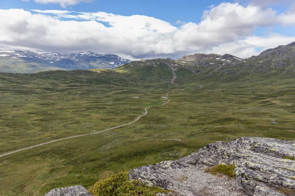 Camino de tierra que pasa en un valle entre montañas en Noruega, enfoque selectivo — Foto de Stock