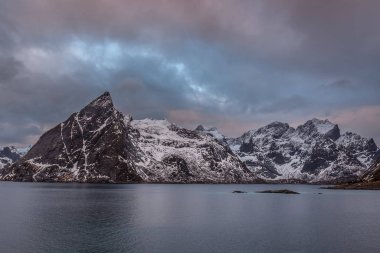 Norveç 'in Lofoten adalarındaki kutup gecesinde mavi saatin altında gün batımı.