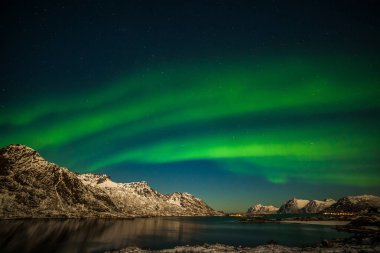Kuzey kutup ışıkları Norveç 'teki gezici fotoğrafçı dağlarında Aurora Borealis gökyüzü yıldızını avlıyor. uzun deklanşör hızı.