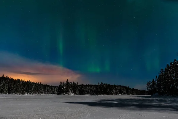 Luces polares dramáticas, Aurora boreal con muchas nubes y estrellas a la luz de la luna en el cielo sobre un lago congelado y un bosque nevado en Suecia. larga velocidad de obturación . — Foto de Stock