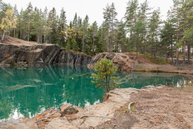 Old abandoned silver mine with blue, emerald water on a sunny evening. silverberg in Sweden. selective focus clipart