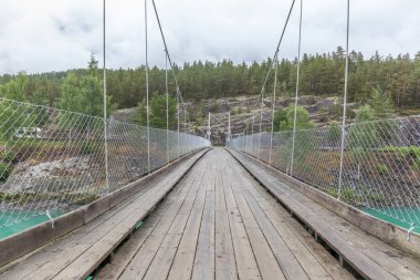 Norveç 'teki dağ nehri üzerindeki asma köprü. Peyzaj. Turkuaz nehir. Norveç 'te hızlı akan dağ nehri