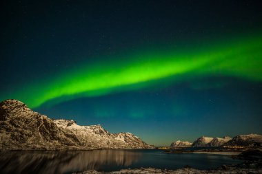 Dramatik aurora borealis, kuzey ışıkları, fiyort dağları üzerinde kutup ışıkları Avrupa 'nın kuzeyinde gökyüzünde birçok yıldız, Lofoten adaları, Norveç, uzun kepenk hızı.