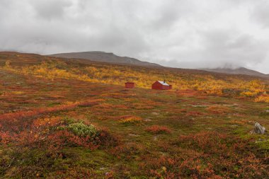 Dağın yamacında küçük evler var. Sonbahar, Sarek, İsveç