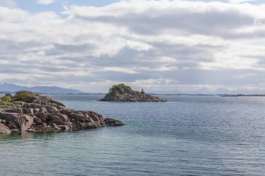 Norveç 'te gizemli bir fiyort. Kutup gününde suyun üzerinde dağlar ve sis vardı. Gece yarısı güneşi, seçici odak