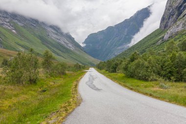 Norveç dağlarının bulutlarıyla çevrili gizemli bir vadiye giden yol..