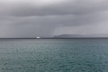 Kutup gününde Norveç fiyortlarını ziyaret etmek için gemi, gece yarısı güneşi. Norveç 'te karanlık bulutları olan gizemli bir fiyort. Dağlar ve sis suların üzerinde süzülüyor.