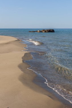 Kumsaldaki mavi deniz dalgalarının görüntüsü. Ufuk çizgisi. Hazar Denizi, kumtaşı kıyısı. Kazakistan, ustyurt, seçici odak, uzun deklanşör hızı
