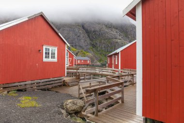 Geleneksel kırmızı ahşap evler, Nusfjord küçük balıkçı köyünde rorbuer, Lofoten adaları, Norveç.