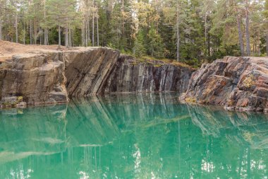 Güneşli bir akşamda mavi zümrüt suyuyla terk edilmiş eski gümüş madeni. İsveç 'in merkezindeki Silverberg. seçici odak