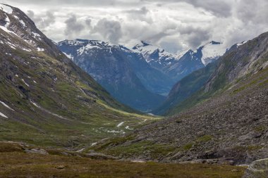Norveç 'te bulutlarla çevrili dağlardaki yeşil vadinin havadan görünüşü