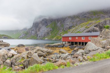 Geleneksel kırmızı ahşap evler, Nusfjord küçük balıkçı köyünde rorbuer, Lofoten adaları, Norveç.