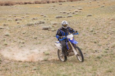 Altai, Moğolistan - 11 Haziran 2017: Moğolistan tepelerinde motosiklet süren adam.