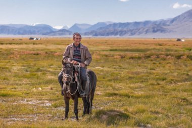 Altai, Moğolistan - 11 Haziran 2017: Moğol atlısı durdu, turistlere baktı ve onlara güldü.