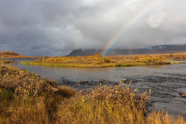 Rainbow over mountain river in the Arctic mountains of a Sarek National Park.