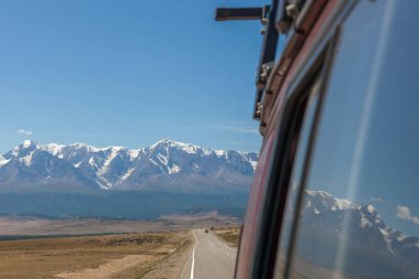 Belukha Dağı arabanın camına yansıyor. Altai. Belukha Dağı, Altai 'nin Altın Dağları adlı Dünya Mirası Alanının bir parçasıdır..