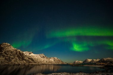 Kutup ışıkları, aurora borealis, kuzey ışıkları, gökyüzünde birçok yıldız olan kuzey ışıkları Avrupa 'nın kuzeyindeki dağların üzerinden, Lofoten adaları, Norveç, uzun kepenk kapama hızı.