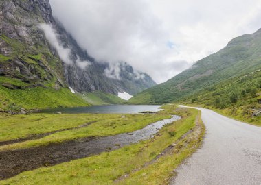 Norveç dağlarının bulutlarıyla çevrili gizemli bir vadiye giden yol..