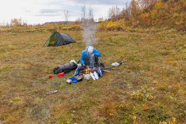 Bir turist yemek pişirmek için ateş yakar, sonbahar, Sarek İsveç