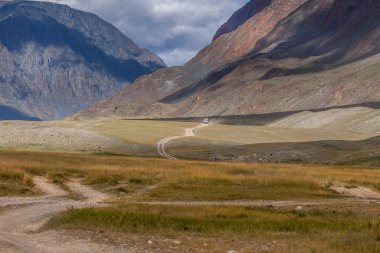 Car on winding road. Mongolian landscapes in the Altai Mountains, wide landscape. clipart
