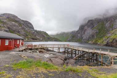 Geleneksel kırmızı ahşap evler, Nusfjord küçük balıkçı köyünde rorbuer, Lofoten adaları, Norveç.
