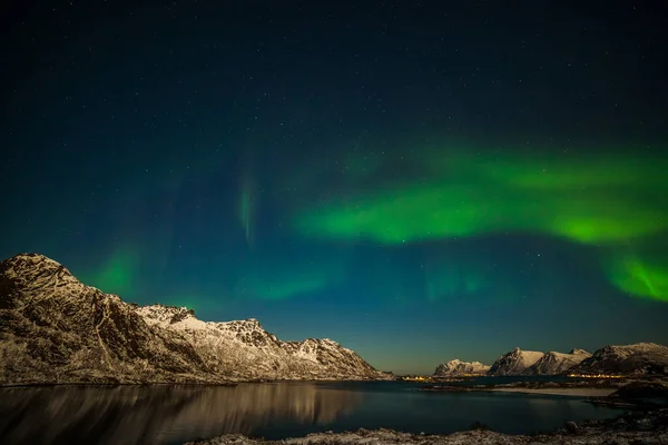 オーロラはフィヨルドの山の上にあり 多くの星がロフテン島 ノルウェー 長い露出の空にあります — ストック写真