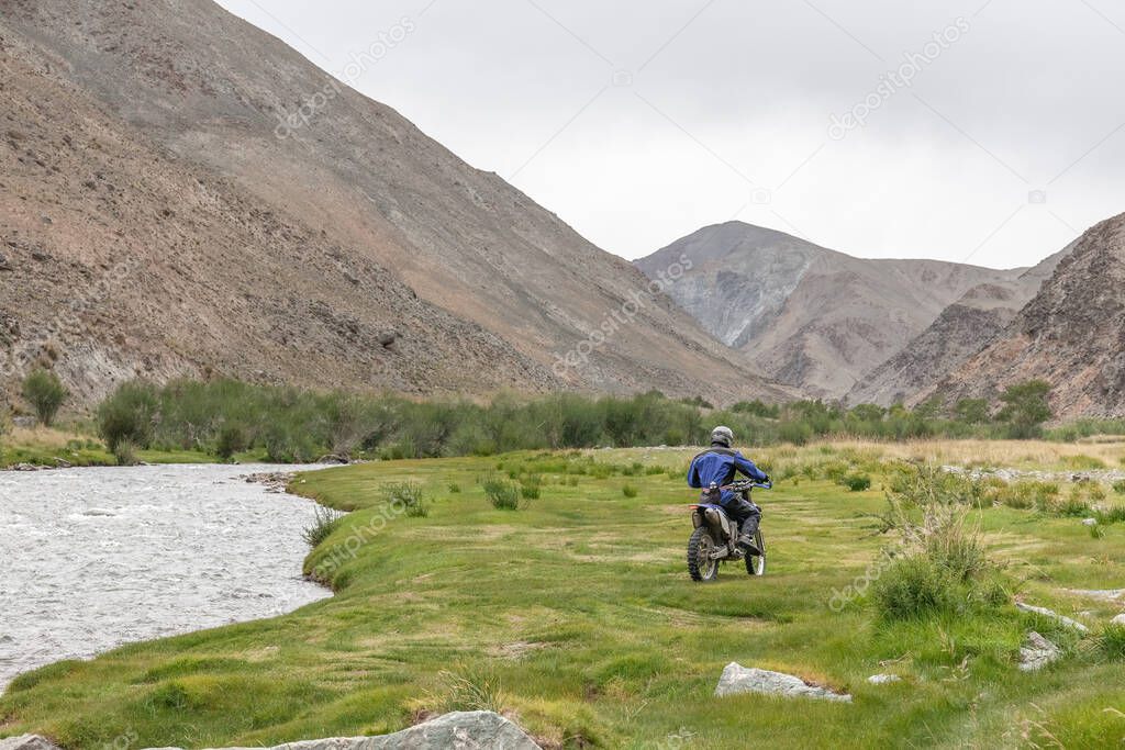 Tourists in the middle of the green oasis sprouting from rocky soil of Altai Mountains Mongolia