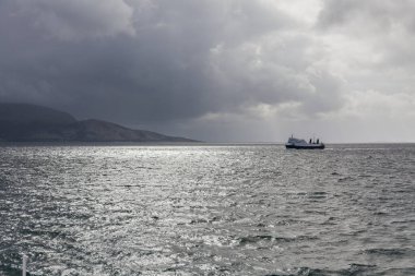 Kutup günündeki Norveç fiyortlarının mavi sularında yol alan gemi, gece yarısı güneşi