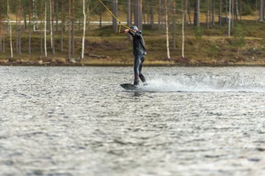 Fagersta, İsveç - Maj 01, 2020: Gölde sörf yapan sörfçü.