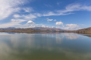 Altai dağlarındaki vahşi dağ gölü, yaz manzarası, Moğolistan manzarası. Bayar-Ulgii 'deki Altai Tavan Bogd Ulusal Parkı. Karlı dağların arkasındaki manzaralı vadi..